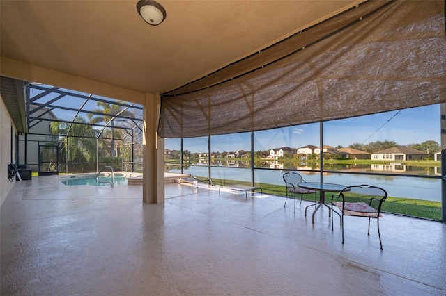 view of patio featuring a lanai, a water view, and an outdoor pool