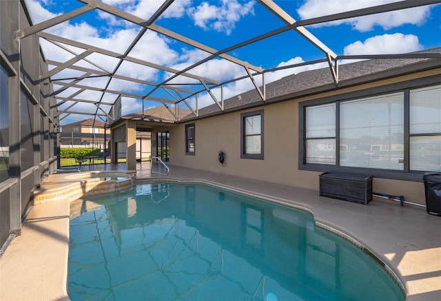 view of pool with a pool with connected hot tub, glass enclosure, and a patio