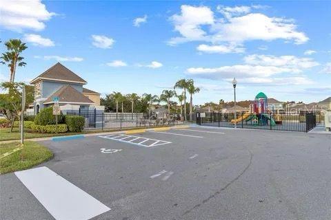 uncovered parking lot featuring playground community and fence