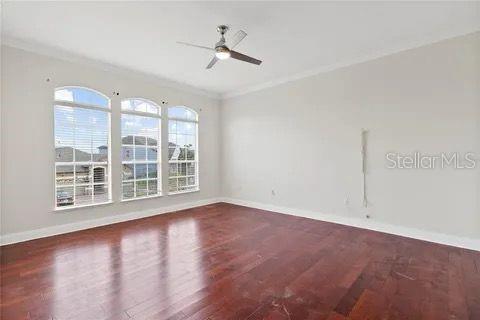 unfurnished room featuring dark wood-style floors, baseboards, and crown molding