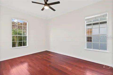 unfurnished room featuring a ceiling fan, vaulted ceiling, baseboards, and wood finished floors