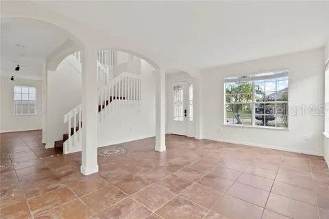 entryway featuring tile patterned flooring, stairway, and arched walkways