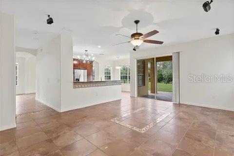 spare room with ceiling fan with notable chandelier