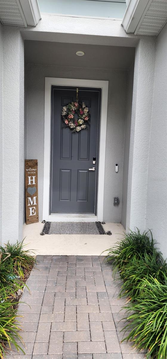 doorway to property featuring stucco siding