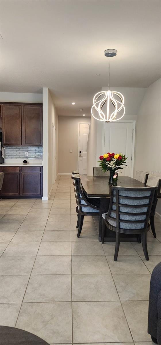 dining area featuring light tile patterned floors, recessed lighting, baseboards, and an inviting chandelier