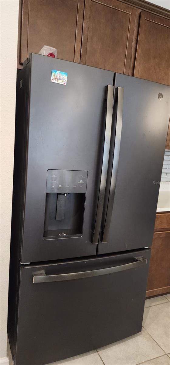 room details featuring light countertops, dark brown cabinetry, and stainless steel refrigerator with ice dispenser