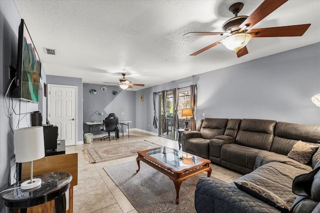 living area featuring visible vents, baseboards, a ceiling fan, a textured ceiling, and light tile patterned flooring