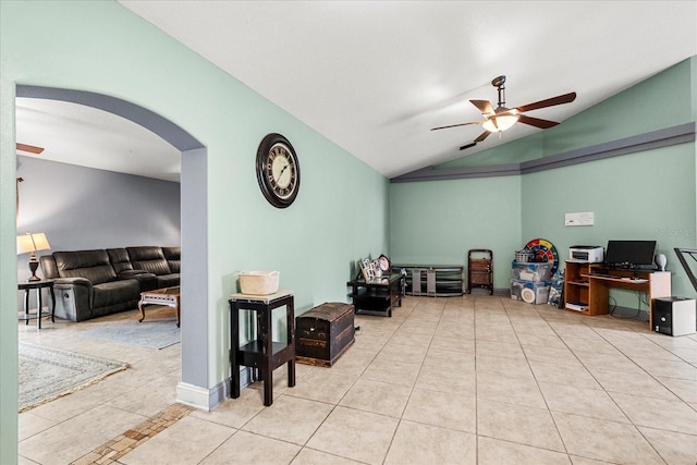 interior space featuring arched walkways, ceiling fan, baseboards, vaulted ceiling, and tile patterned floors