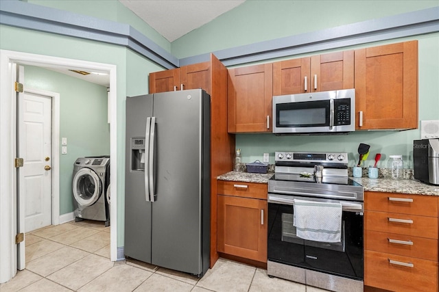 kitchen featuring light tile patterned floors, appliances with stainless steel finishes, and brown cabinets