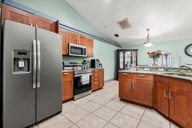 kitchen featuring lofted ceiling, a sink, visible vents, appliances with stainless steel finishes, and brown cabinetry