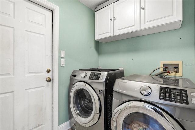 washroom with washer and clothes dryer and cabinet space