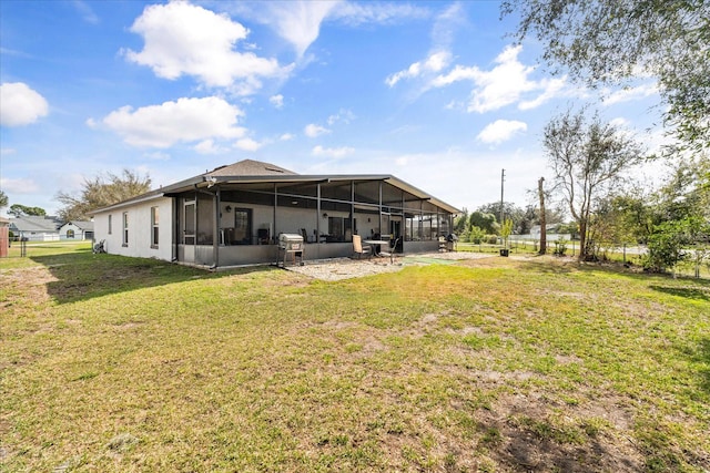 back of house featuring a lawn and a sunroom