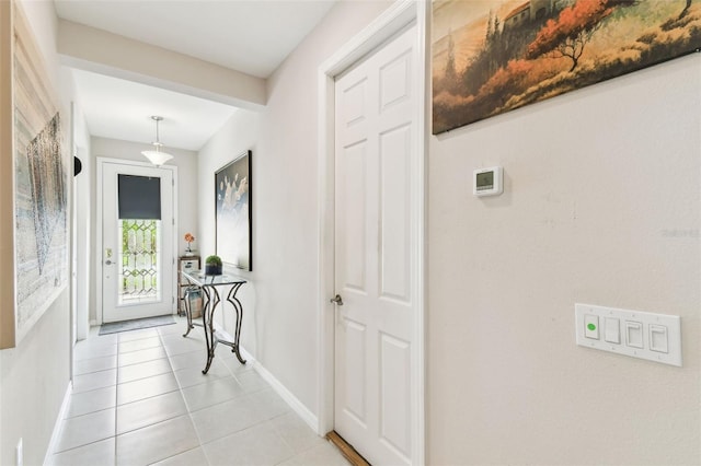 interior space featuring light tile patterned flooring and baseboards