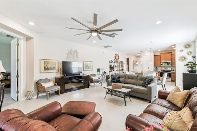 living area with light tile patterned floors, a ceiling fan, visible vents, and recessed lighting