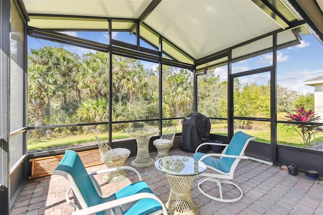 sunroom featuring lofted ceiling and plenty of natural light