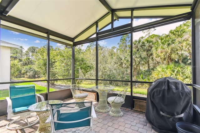 sunroom / solarium with vaulted ceiling with beams