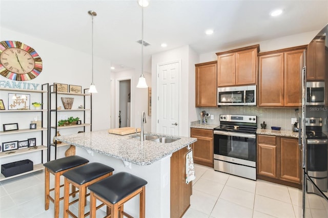 kitchen with brown cabinets, visible vents, stainless steel appliances, and a sink