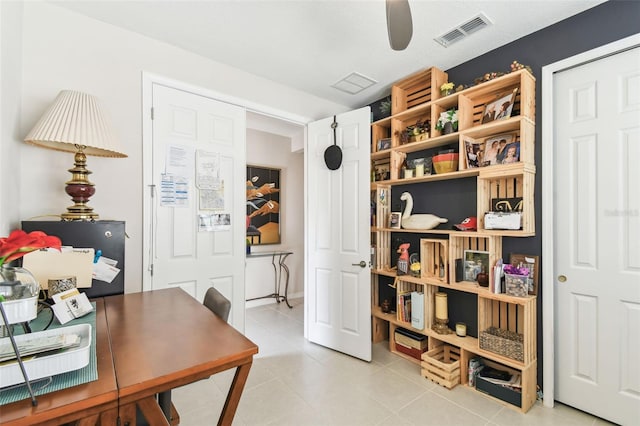 office space featuring a ceiling fan, visible vents, and light tile patterned floors