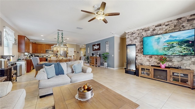 living room with ornamental molding, light tile patterned flooring, visible vents, and a ceiling fan