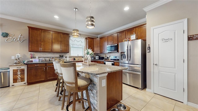 kitchen with light tile patterned floors, light stone counters, a kitchen island, hanging light fixtures, and appliances with stainless steel finishes