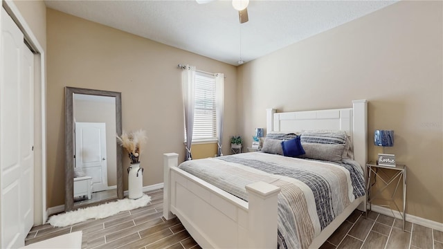 bedroom with a ceiling fan, wood finish floors, a closet, and baseboards