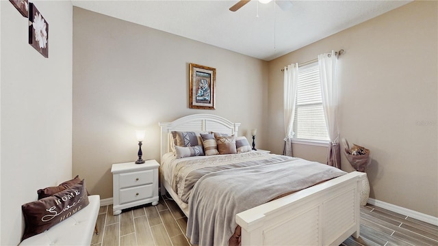 bedroom with wood tiled floor, baseboards, and ceiling fan