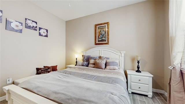 bedroom with wood finish floors and baseboards