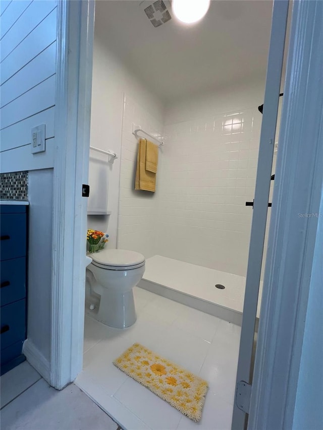 full bathroom featuring toilet, a shower stall, visible vents, and tile patterned flooring