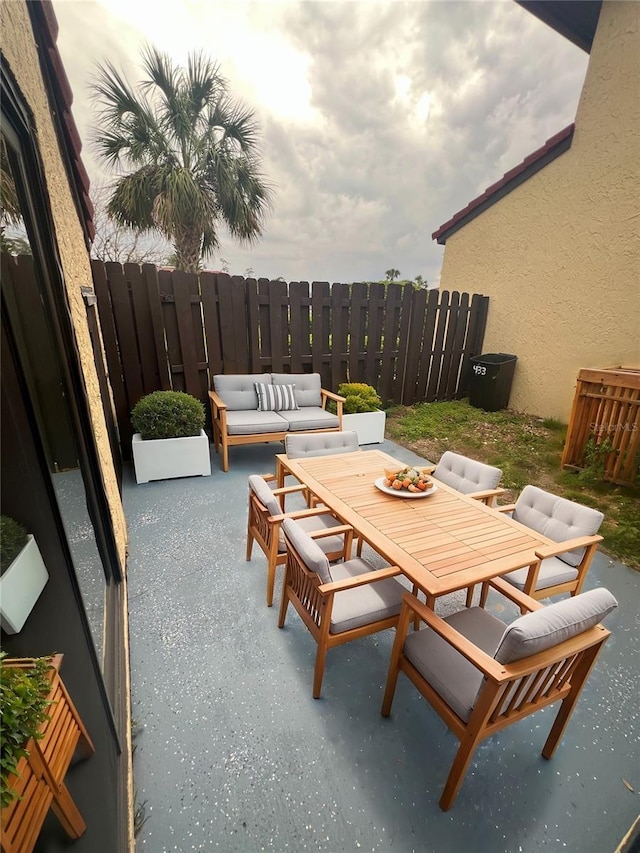 view of patio with outdoor dining area, fence, and an outdoor hangout area