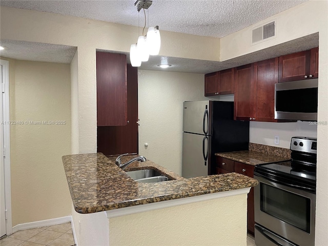 kitchen featuring electric range, visible vents, freestanding refrigerator, a peninsula, and a sink