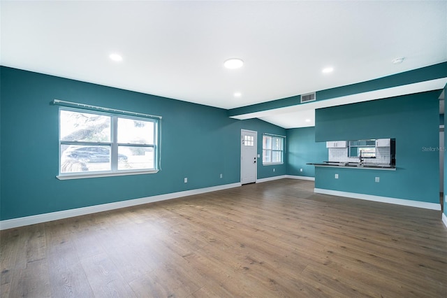 unfurnished living room featuring baseboards, visible vents, dark wood finished floors, and recessed lighting