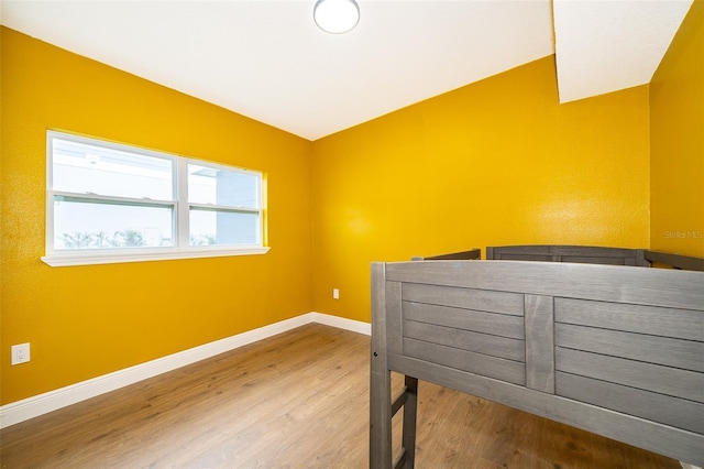 bedroom with baseboards and wood finished floors