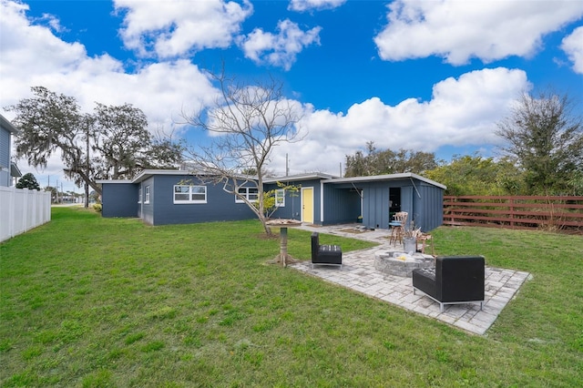 rear view of property with a patio area, a fenced backyard, a fire pit, and a lawn