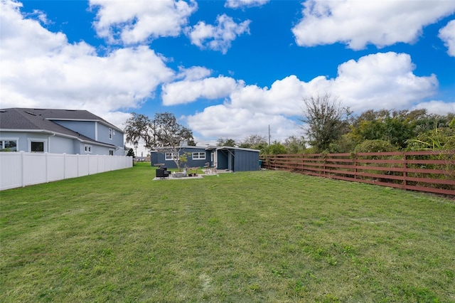 view of yard with an outdoor structure and a fenced backyard