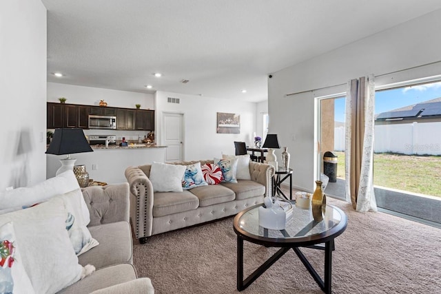 living area with carpet, visible vents, and recessed lighting