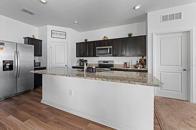 kitchen featuring appliances with stainless steel finishes, dark wood-type flooring, a sink, and visible vents