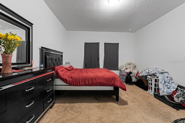 bedroom with a textured ceiling and light colored carpet