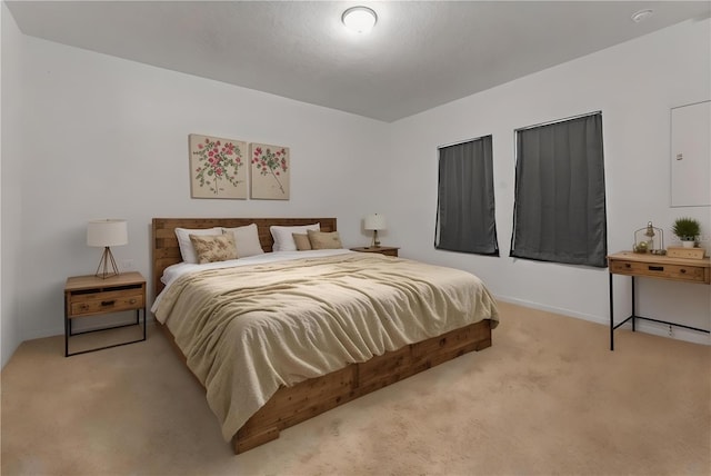 bedroom with baseboards and light colored carpet