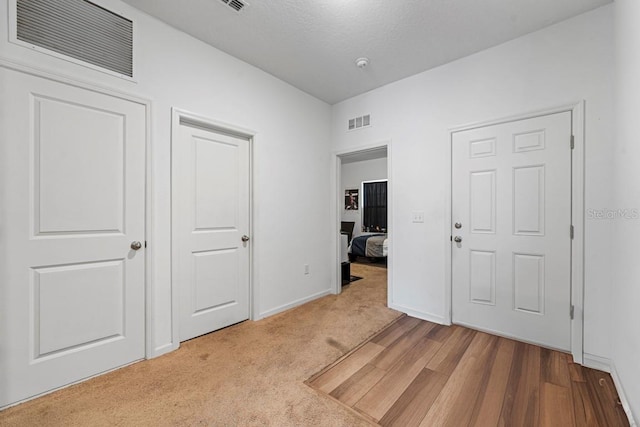 unfurnished bedroom featuring carpet floors, visible vents, and baseboards