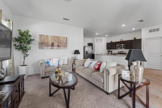 living area with light colored carpet, visible vents, and recessed lighting