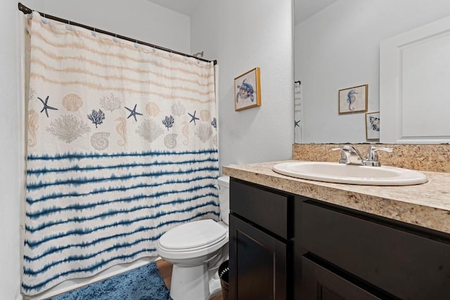 full bathroom featuring a shower with shower curtain, vanity, and toilet