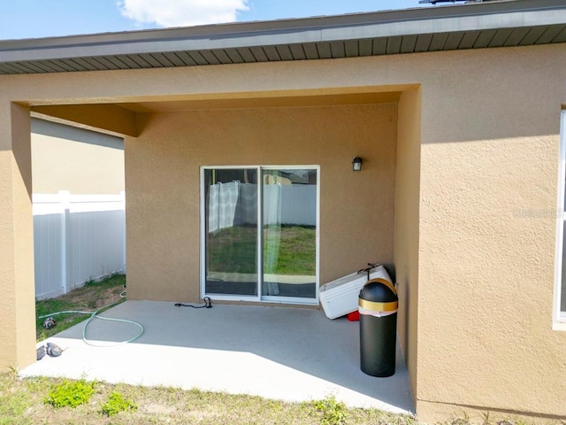 exterior space featuring fence, a patio, and stucco siding