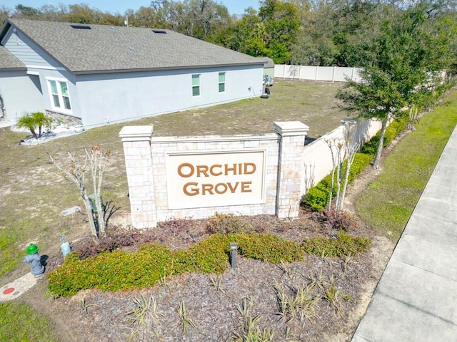 community sign with fence and a yard