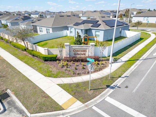 community sign with fence and a residential view