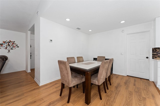 dining room with light wood-type flooring, baseboards, visible vents, and recessed lighting