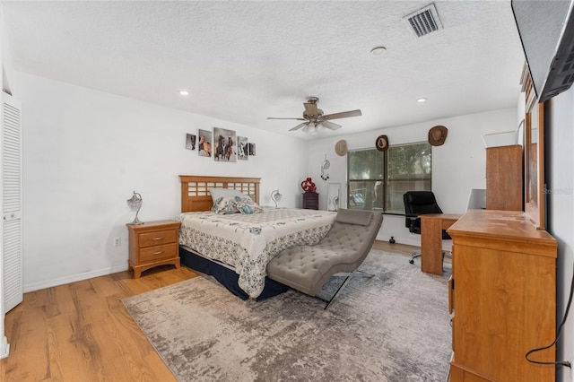 bedroom featuring a textured ceiling, recessed lighting, visible vents, baseboards, and light wood finished floors