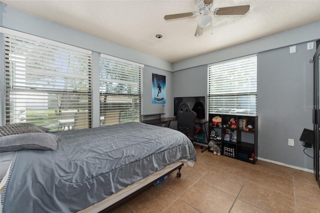 bedroom featuring tile patterned flooring, multiple windows, baseboards, and ceiling fan