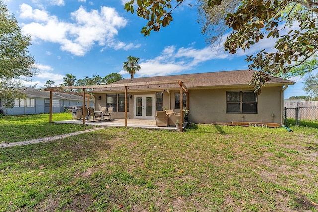 rear view of property featuring a fenced backyard, a yard, french doors, stucco siding, and a patio area