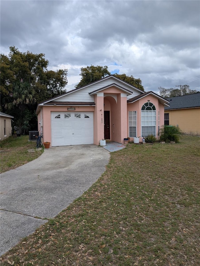 ranch-style house with a garage, concrete driveway, a front lawn, and stucco siding