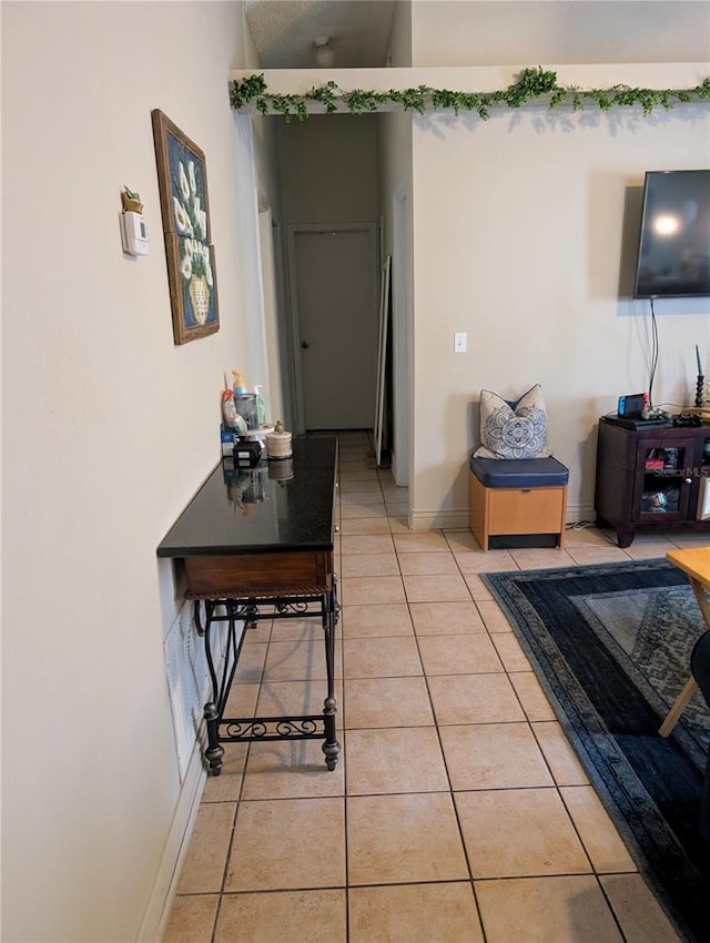 living area featuring light tile patterned floors and baseboards